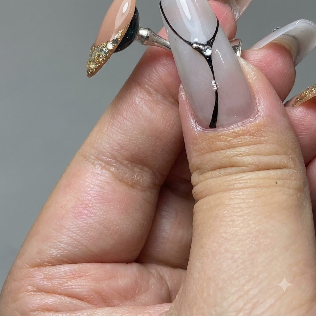 Un pennello per unghie che stende il gel platino oro sulla punta di ununghia di pratica.