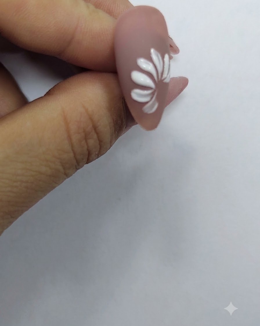 Un anello completo di petali bianchi che formano la forma di una margherita su uno sfondo color carne.