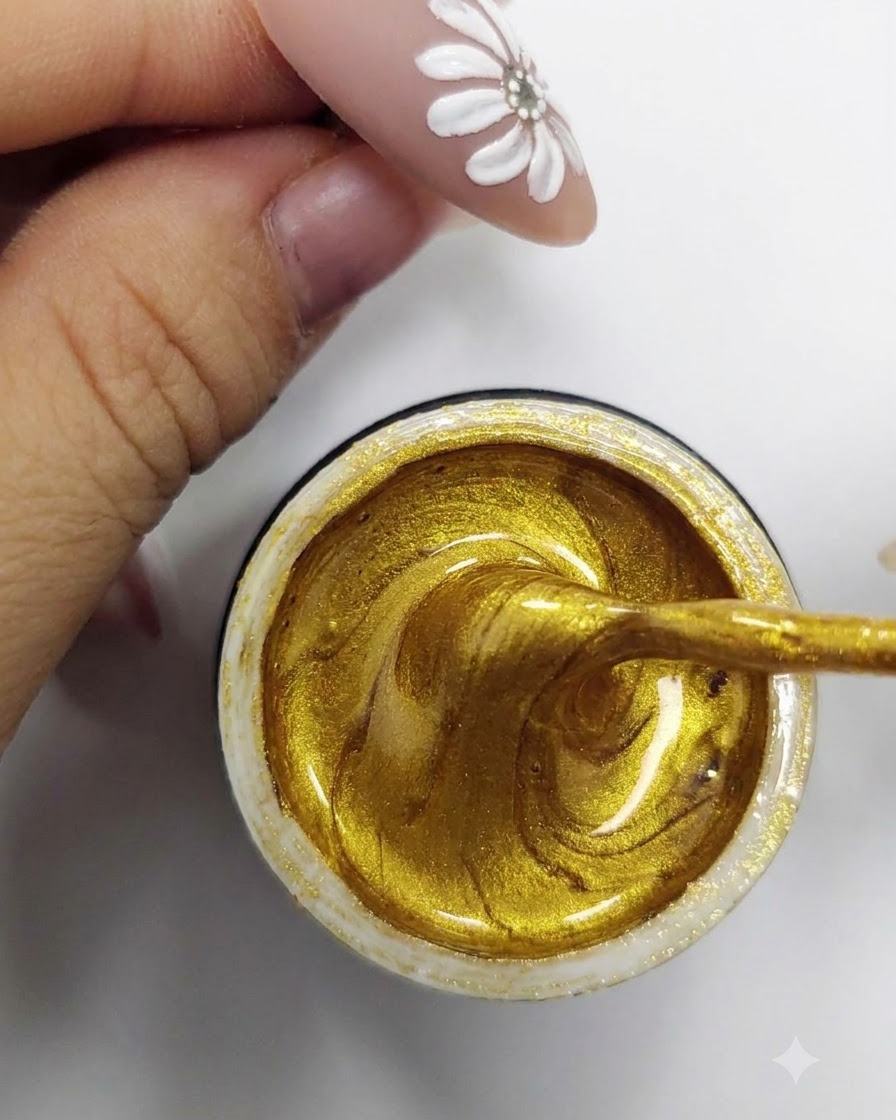Un pennello liner sottile che raccoglie gel semipermanente oro vibrante dallinterno di un contenitore aperto.