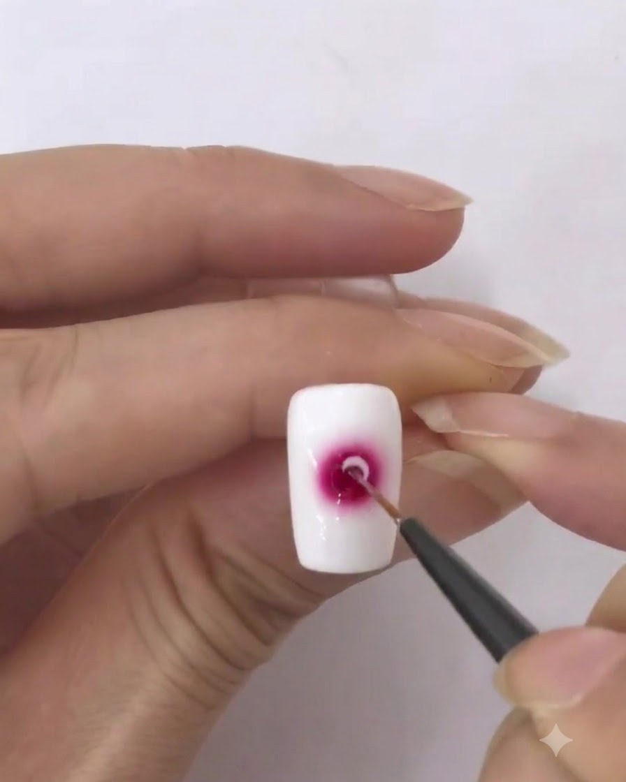 Un pennellino liner caricato con una piccola quantità di smalto gel bianco.
