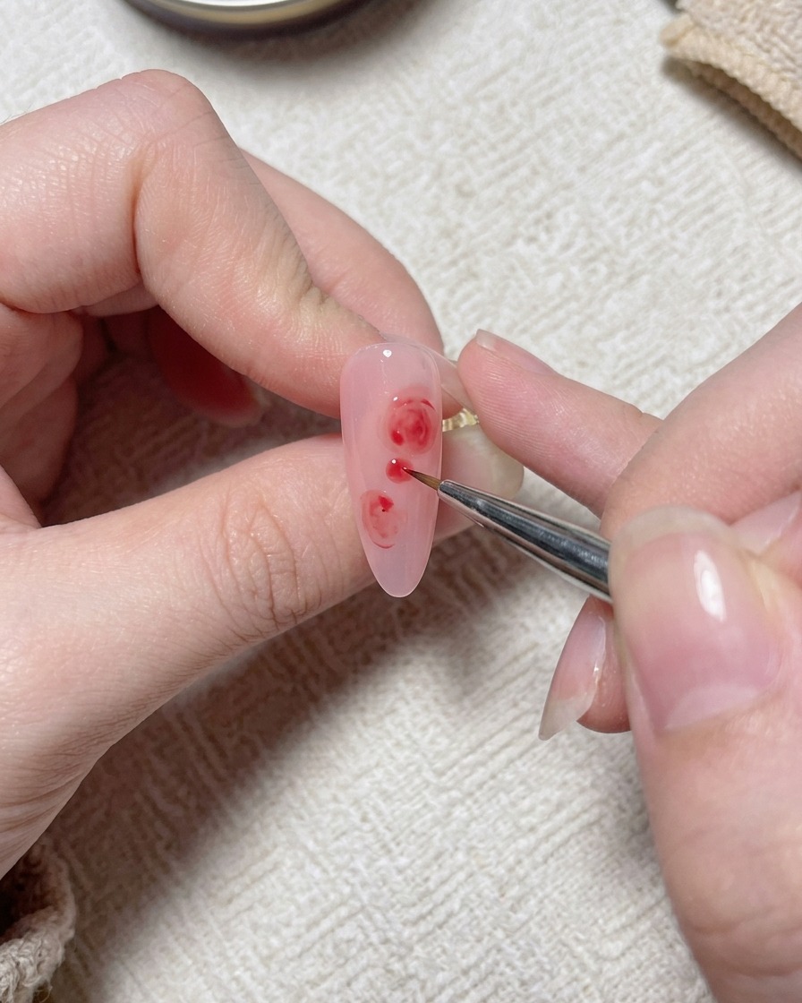 Un pennello fine applica piccoli dettagli picchiettati di bianco sul design della rosa rosa.