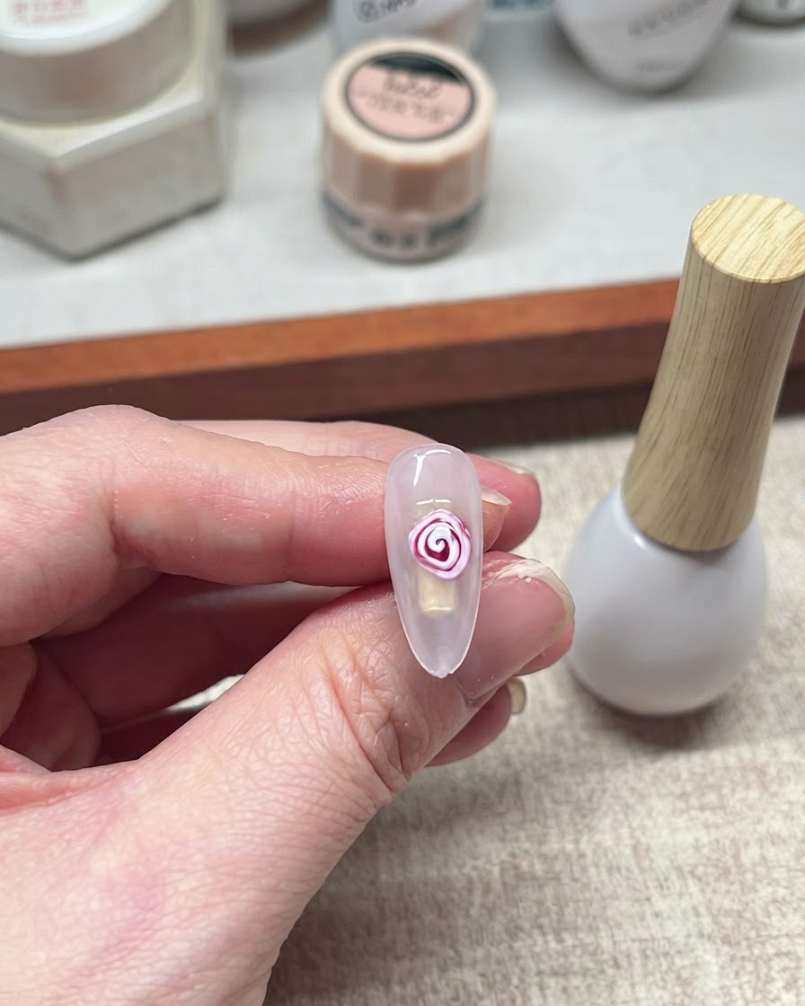 Un design finito di rosa in blooming gel rosso e bianco su ununghia.