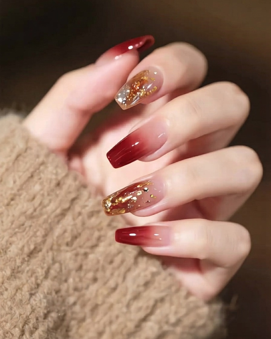 Uno scatto in primo piano di una mano con nail art dettagliata, che mostra un cristallo statement prominente e sottili linee dorate.