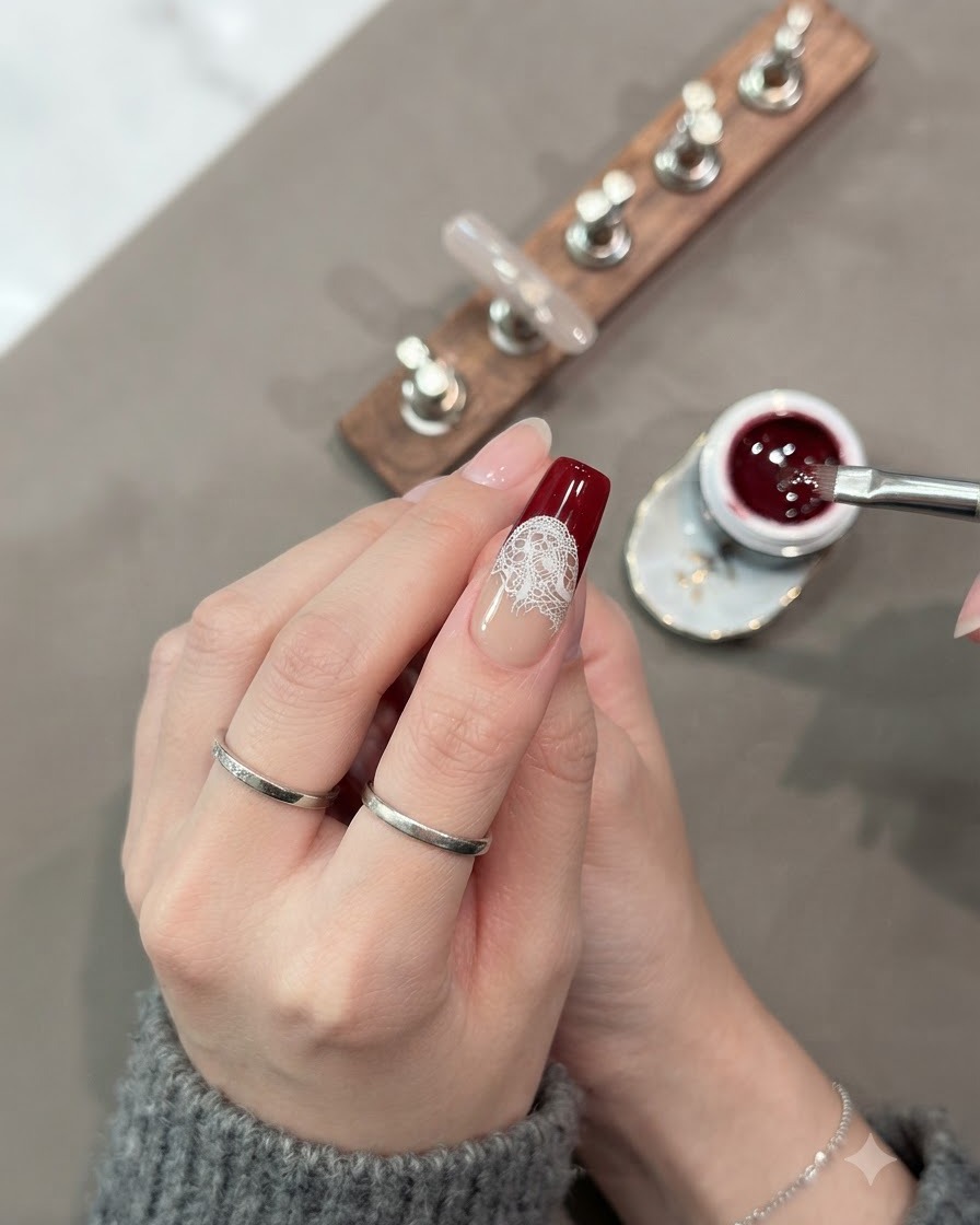 Un pennello riempie completamente la sezione inferiore della punta dellunghia con gel cat-eye rosso scuro.
