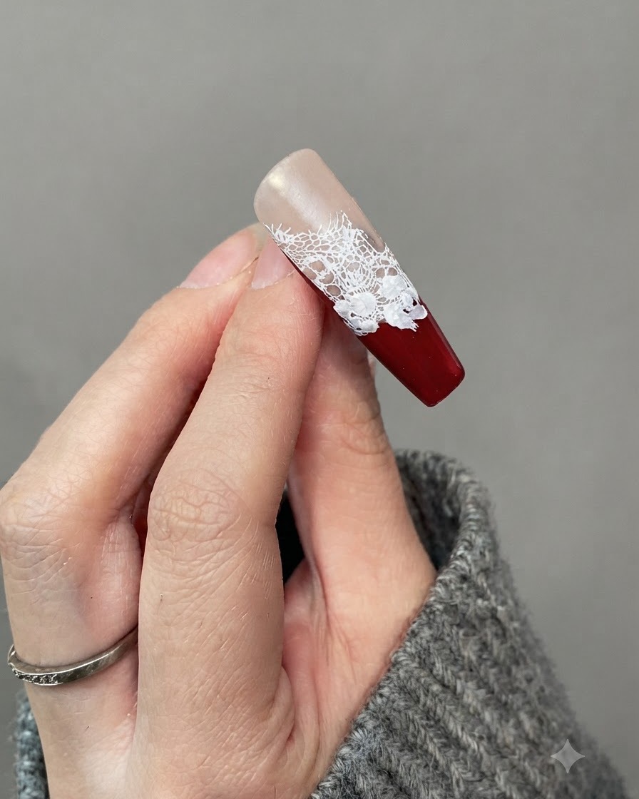 Primo piano di ununghia che mostra piccoli dettagli di foglie bianche dipinte attorno ai bordi dei fiori di rosa bianca.