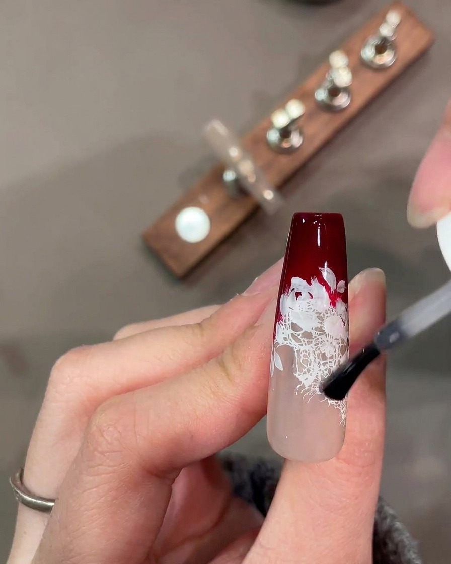 Una tavolozza per acquerelli con pigmenti rossi, verdi e rosa misti per nail art.