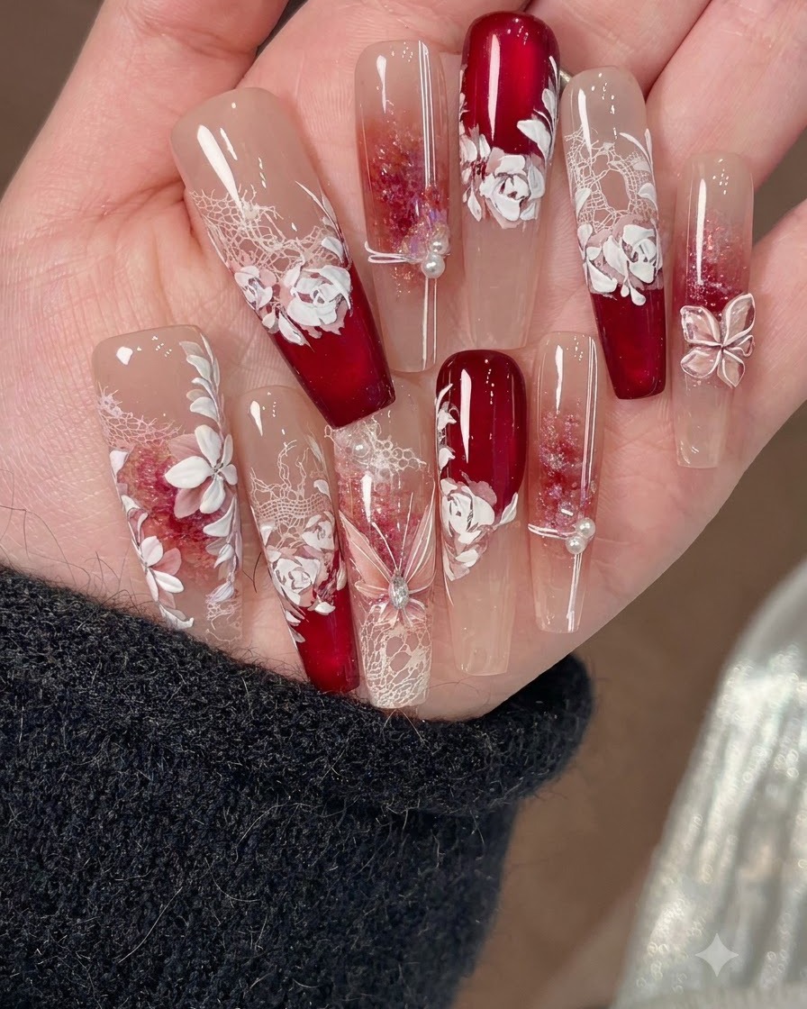 Un pennello fine per nail art disegna sottili linee di accento sopra le decorazioni per unghie floreali bianche.