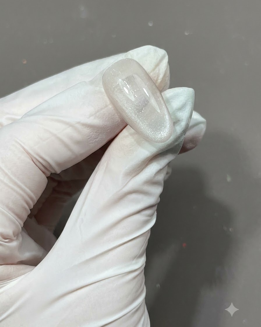 Un pennello che applica uno strato di top coat opaco su ununghia texturizzata con stelle incapsulate.
