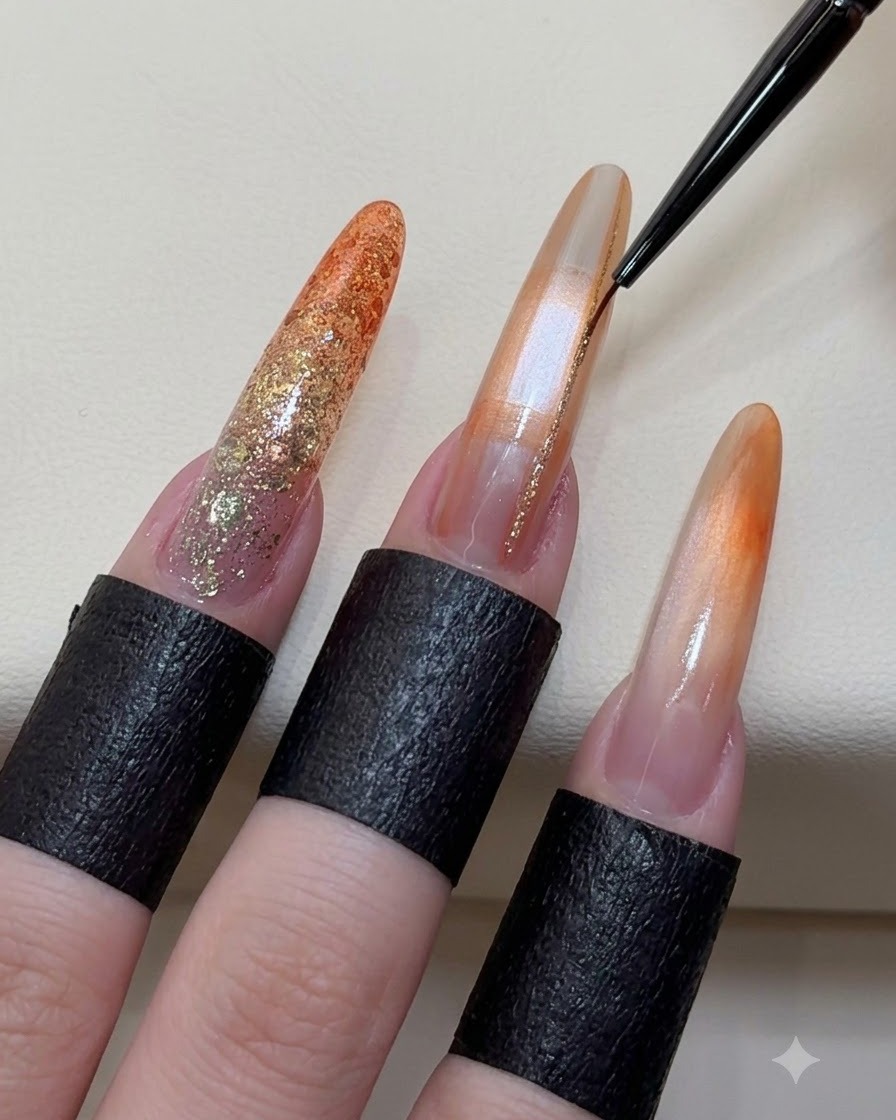 Un pennello liner fine che applica linee scintillanti color oro champagne su ununghia in gel decorata.