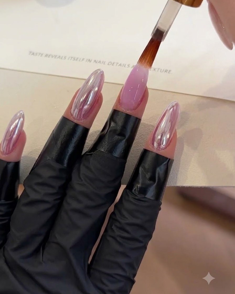 Un pennello che applica uno strato di top coat trasparente su ununghia in gel viola.
