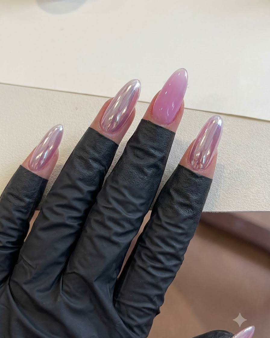 Una mano con unghie in gel viola finite che riposa sotto lilluminazione durante la fase di polimerizzazione.