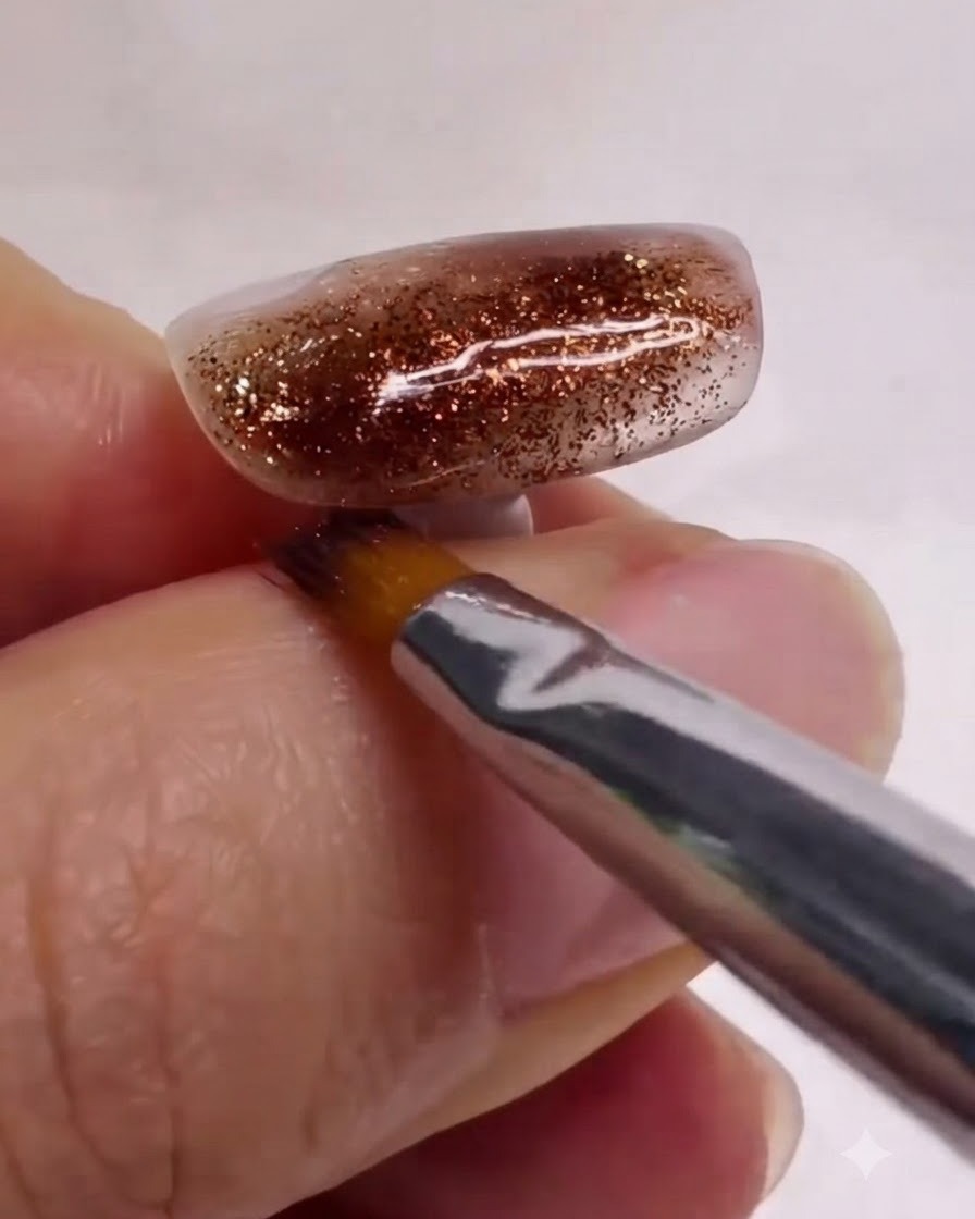 Un pennello pulito per nail art che liscia e sfuma delicatamente gli strati di marmo bianco e marrone su ununghia strutturata.