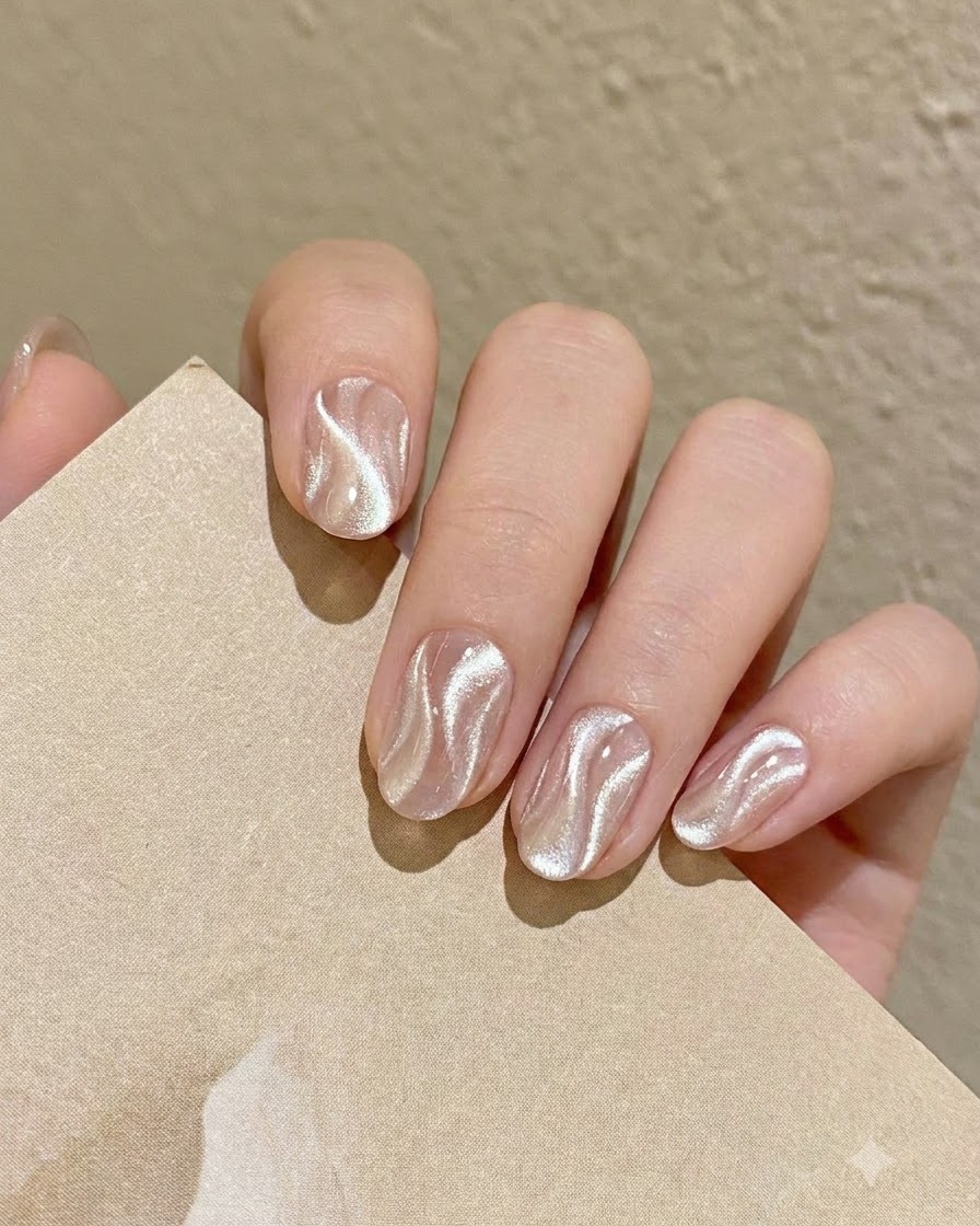 Un pennello sottile da nail art che preleva una piccola quantità di gel cat eye argento brillante dalla tavolozza.