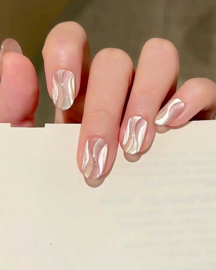 Un pennello di dettaglio fine che applica una pennellata di gel cat eye rosa sulla superficie dellunghia.