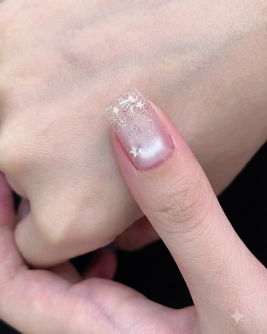 Un pennello da gel ricopre ununghia con uno smalto cat-eye bianco semitrasparente.