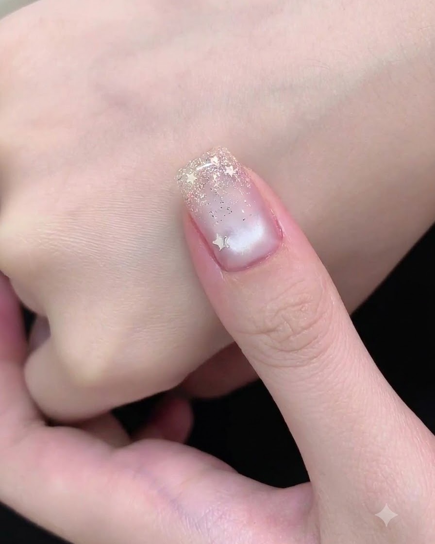 Un pennello da nail art applica dei glitter argento sottili sulla punta dellunghia per creare un effetto sfumato.