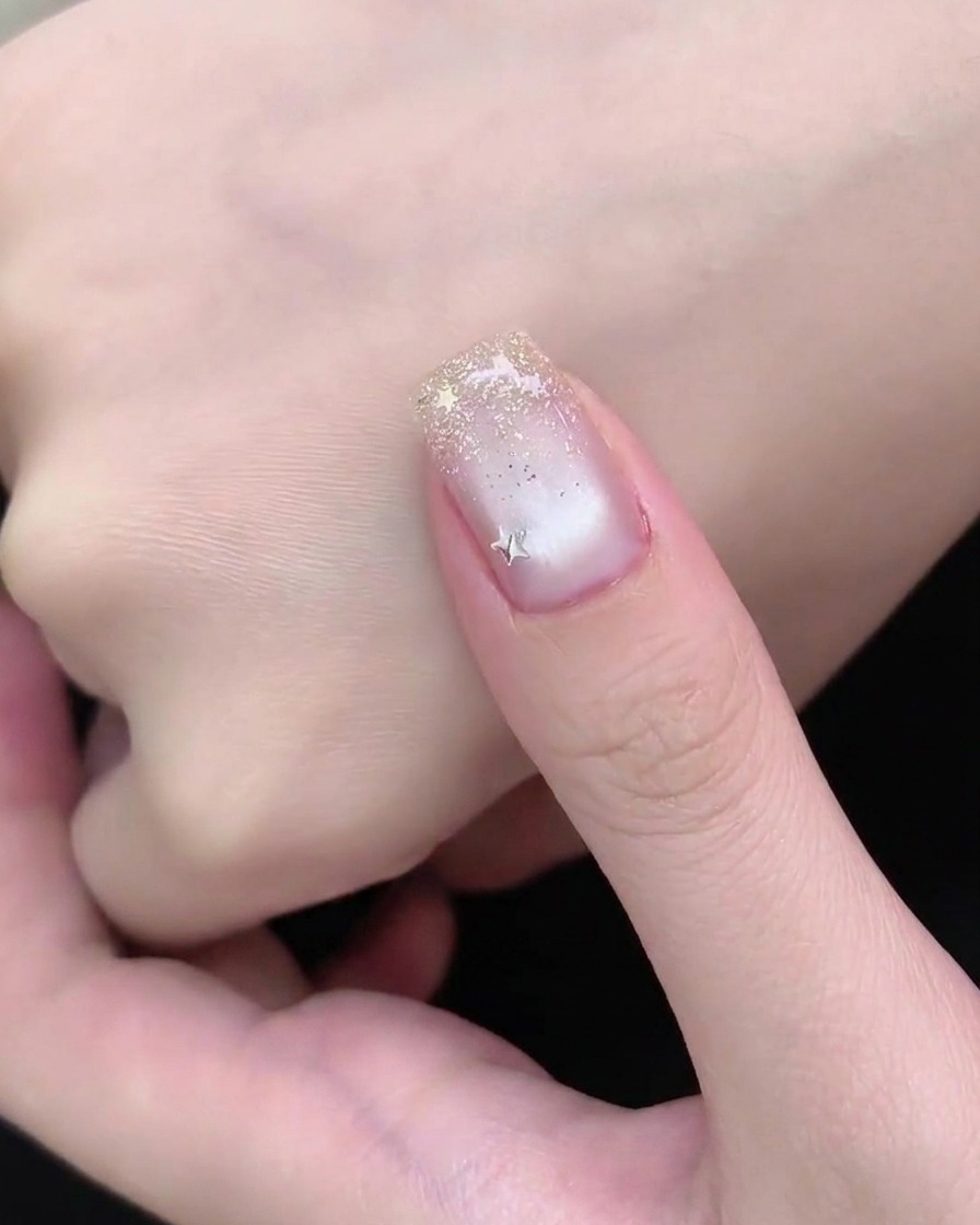 Una mano sotto la lampada UV o LED durante la fase di polimerizzazione finale di una manicure.