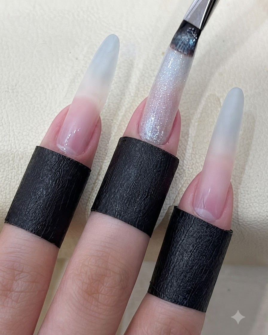Un pennello per unghie che applica il gel cat eye stellato e brillante su ununghia lunga e scolpita.