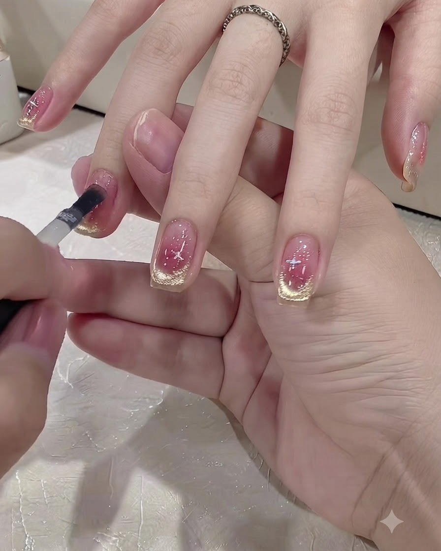 Un piccolo pennello applica uno strato di top coat trasparente su ununghia decorata.