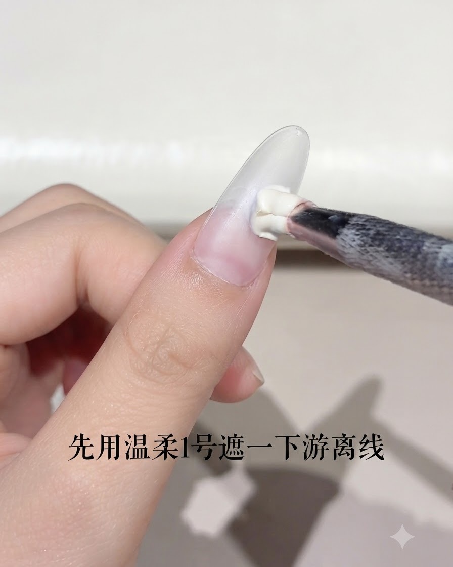 Un pennello per unghie che applica una piccola quantità di gel bianco sul margine libero di ununghia a mandorla.