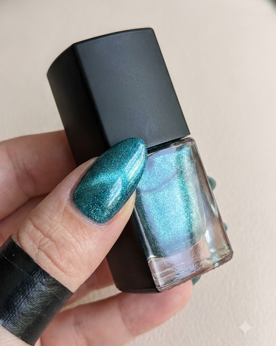 Un flacone di top coat accanto a ununghia polimerizzata pronta per la polvere magica.
