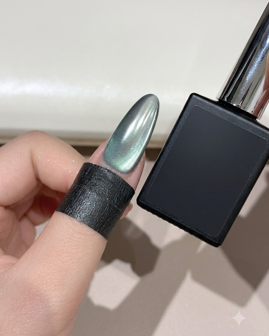 Ununghia a mandorla finita color ciano nebbia cat-eye con luna crescente accanto a un flacone di gel nero.