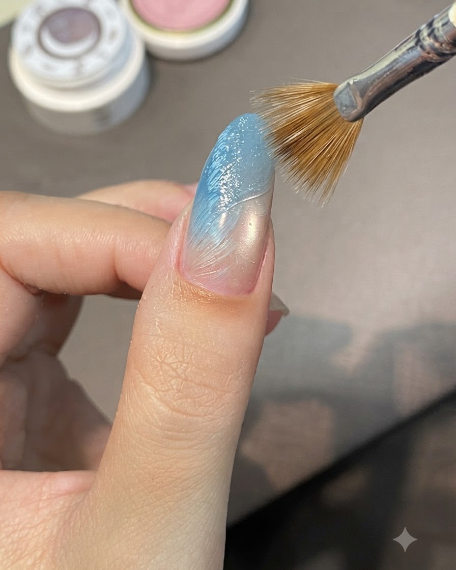 Un pennello a strisce spazza diagonalmente attraverso il gel da scultura bagnato su ununghia con sfumatura blu per formare creste in rilievo.