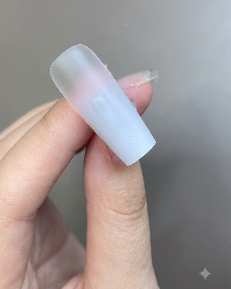 Un sottile strato di gel bianco latte translucido steso sulla superficie dellunghia sfumata.