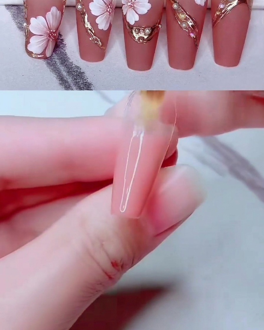 Uno strumento fine per nail art che posiziona piccole perle bianche sulla superficie decorata dellunghia.