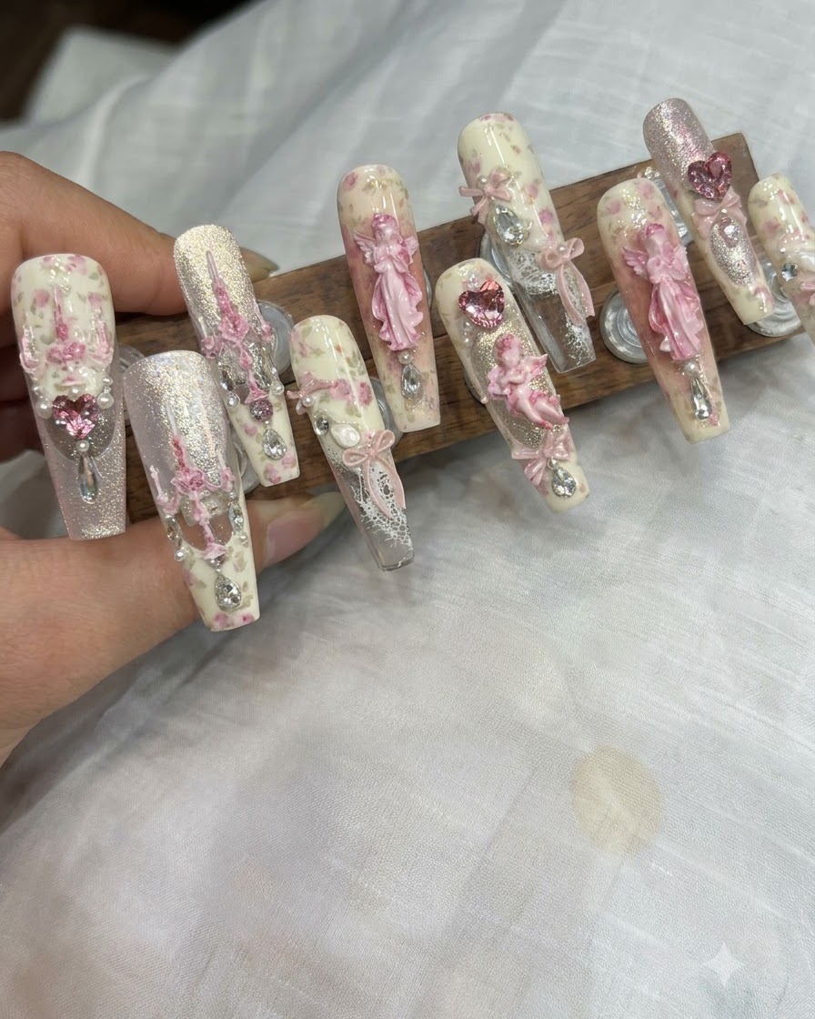 Un pennello per dettagli fini applica minuscoli puntini di gel glitterato al centro di ununghia decorata.
