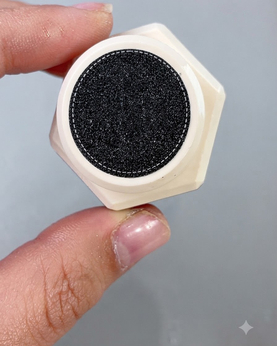 Un pennello da smalto che applica uniformemente un gel cat eye cantalupo brillante su una punta dunghia finta.