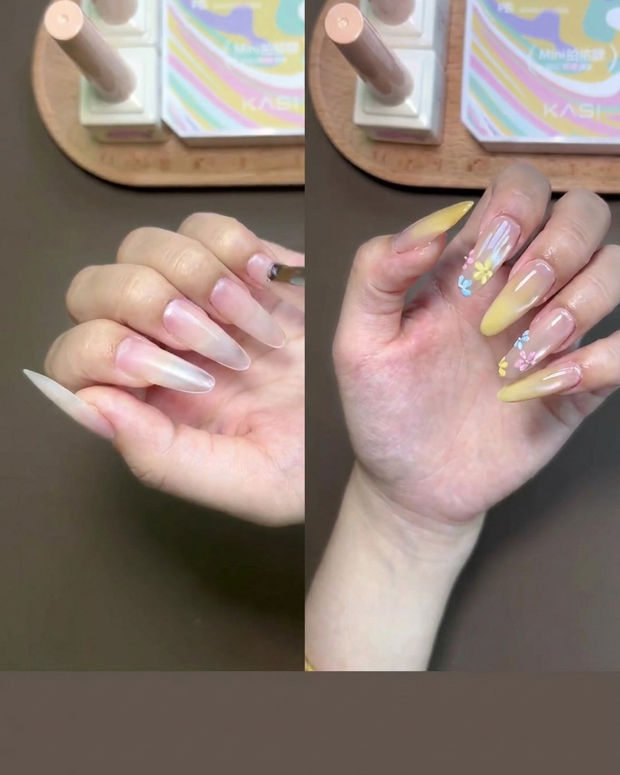 Primo piano di una mano mentre applica il gel base nude sulle unghie con un pennellino.