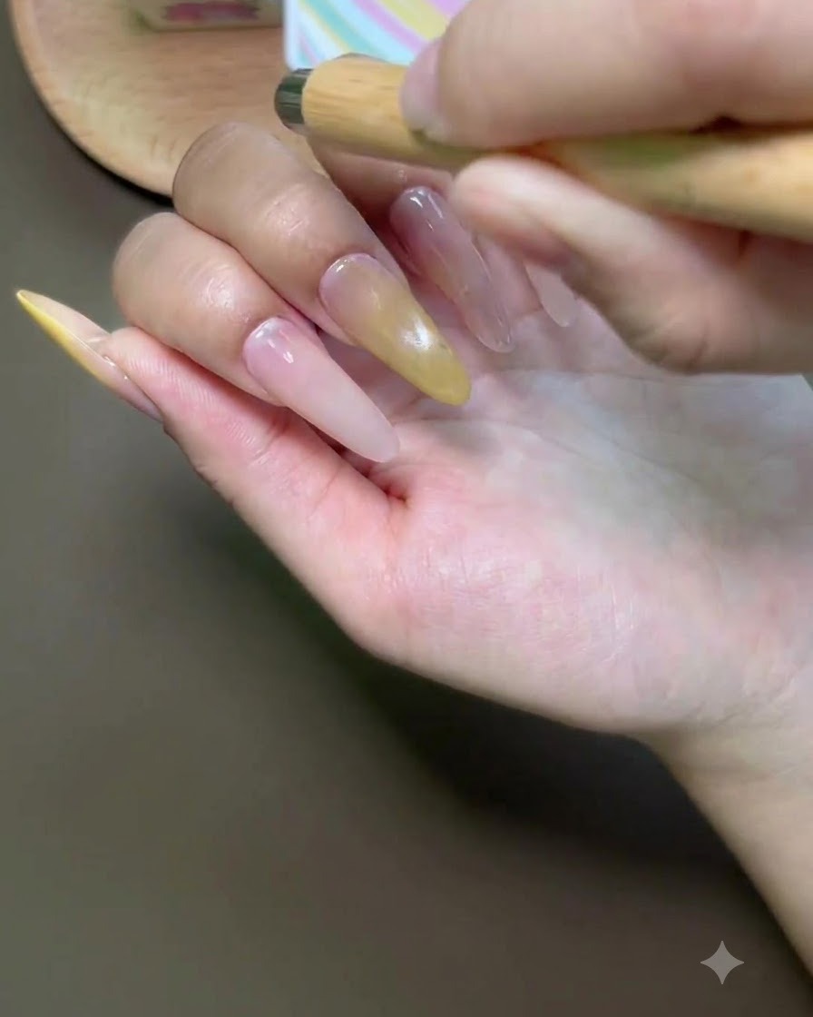 Un pennello che applica lo smalto gel cat-eye sullunghia del dito indice.