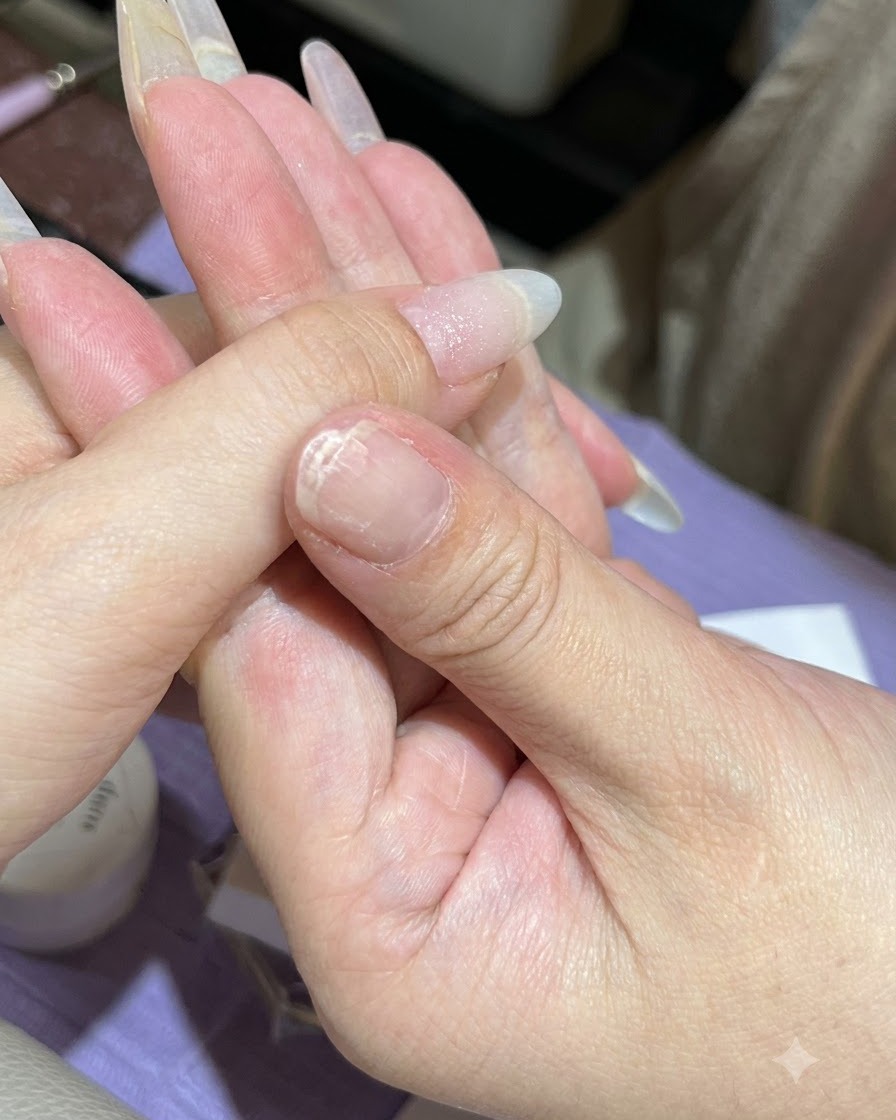 Una spugnetta tampona il gel verde menta sulla punta dellunghia del pollice.