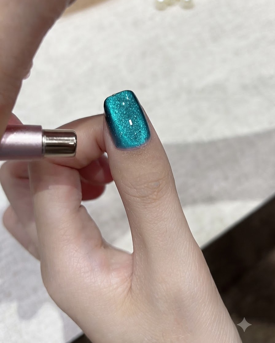 Uno strumento magnetico che regola il riflesso della luce su ununghia in gel cat-eye blu ottanio.