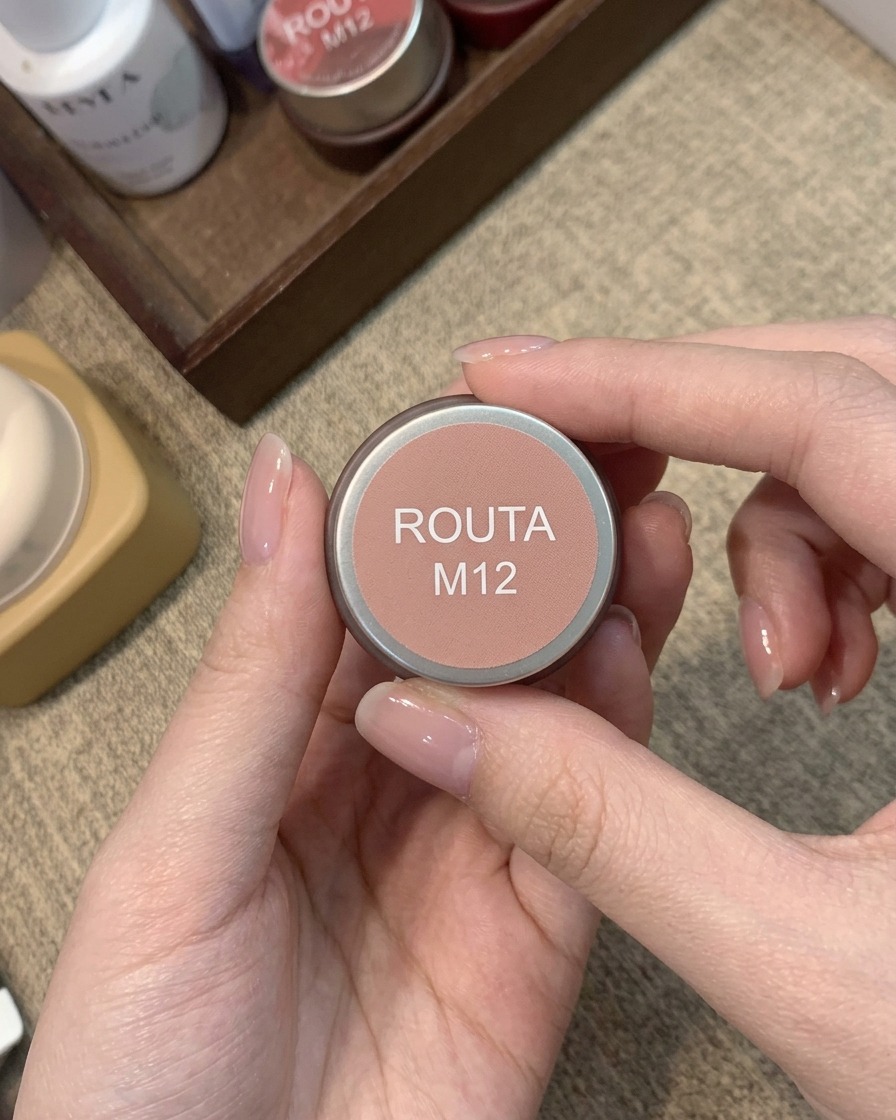 Un piccolo barattolo con etichetta Routa M12 contenente un colore gel blush rosa pesca caldo.