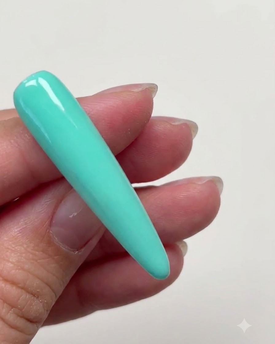 Una lunga unghia a stiletto completamente ricoperta da uno strato liscio di gel colorato verde menta.