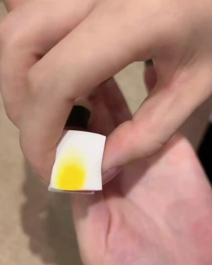 Una spugnetta cosmetica con gel smalto nero vicino a unghia, pronta per tamponare leffetto ombré.