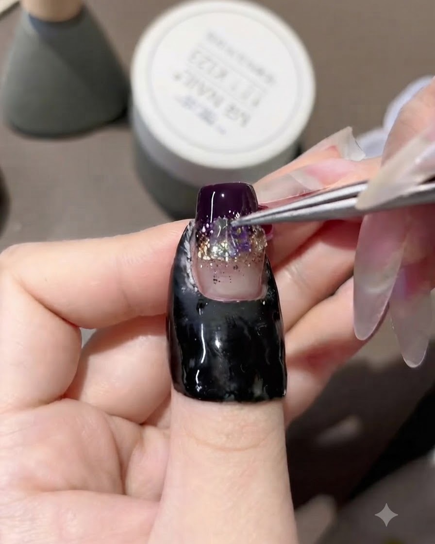 Una pinzetta posiziona gli strass aurora iridescenti al centro di ununghia in gel decorata.