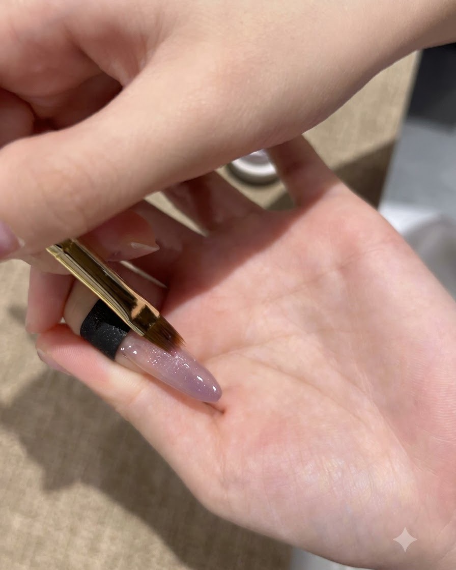Un pennello sottile applica un secondo strato di gel cat-eye viola sulla punta dellunghia.