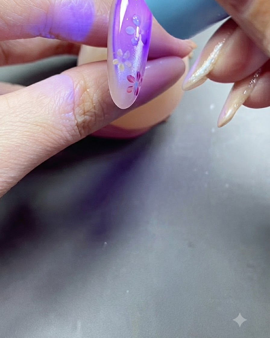 Una mano che posiziona ununghia sotto una luce viola di una lampada UV durante il processo di polimerizzazione.