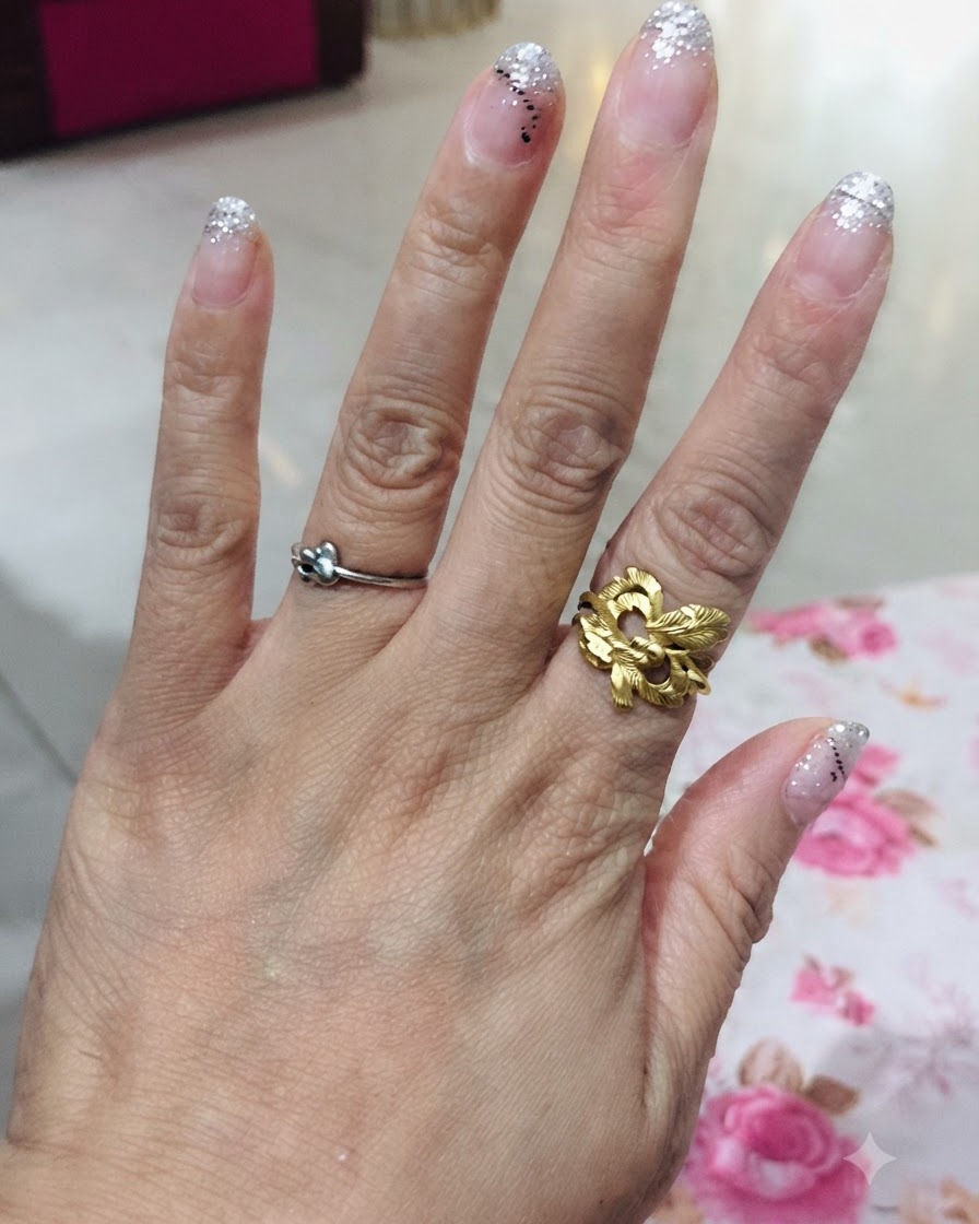 Vista dallalto di una mano che mostra tutte e cinque le dita con un design sfumato in glitter argento.
