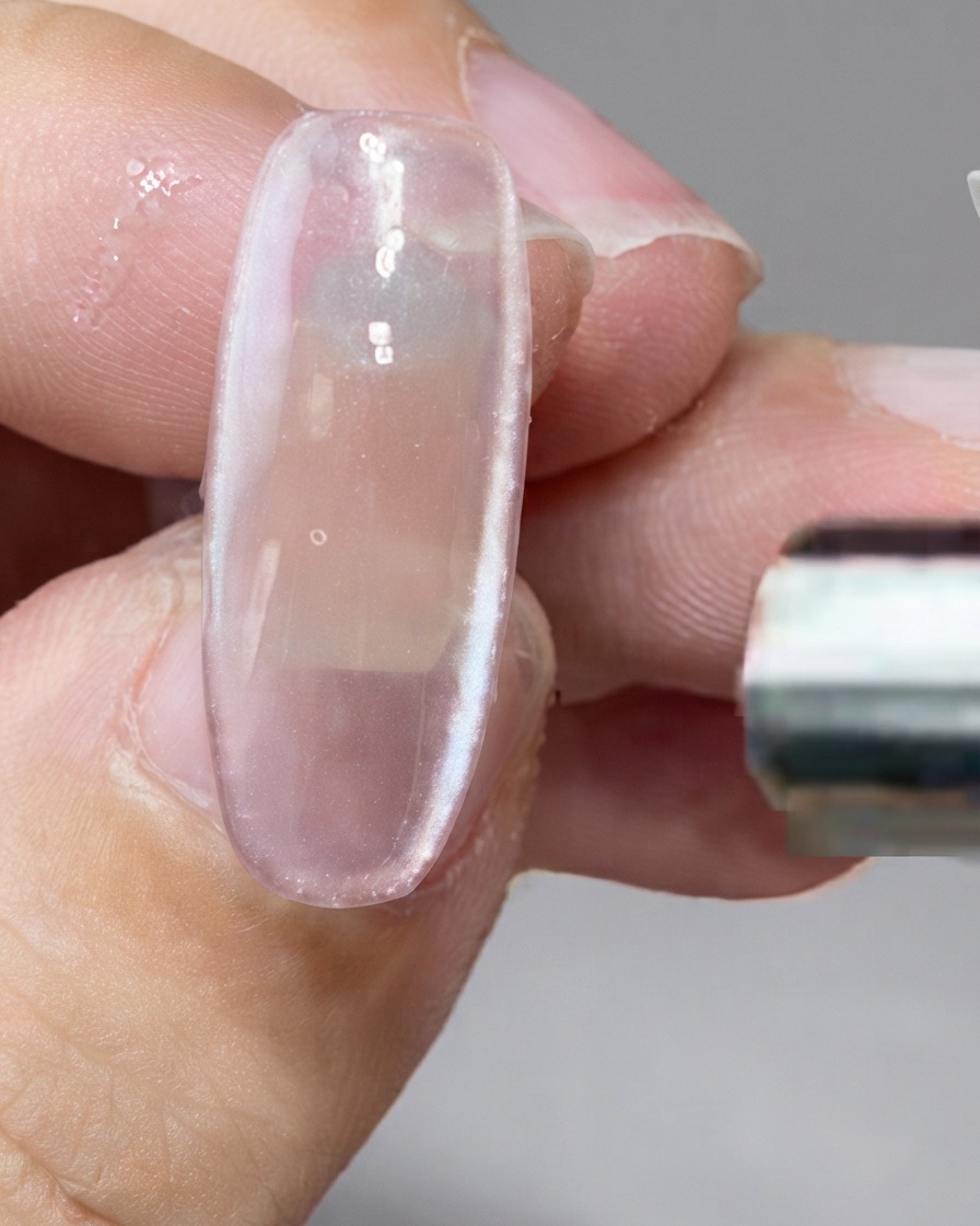 Un magnete a barra che trattiene le particelle magnetiche lungo il lato destro di ununghia.