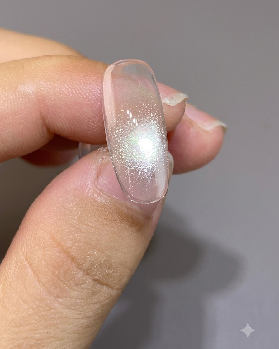 Un magnete posizionato da vicino sopra ununghia, che forma un punto focale cat-eye stretto e luminoso.