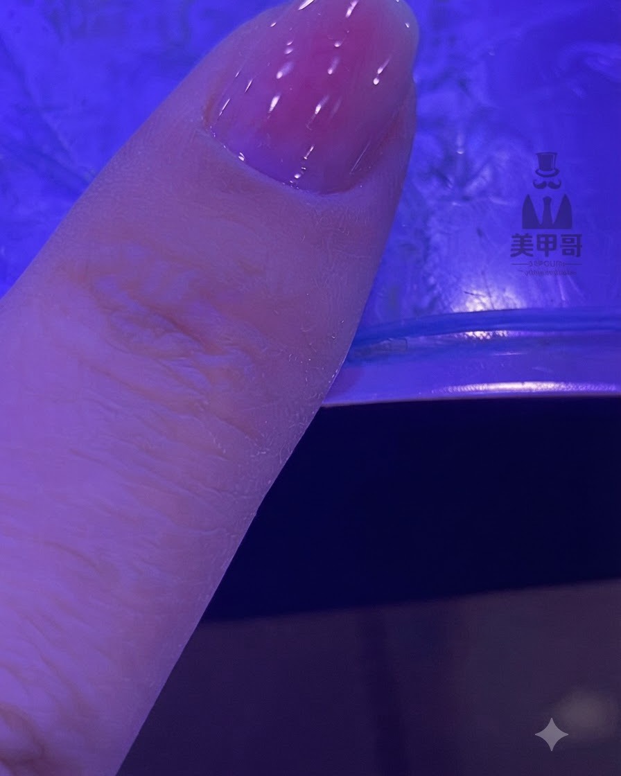 Ununghia con una sfumatura rosa sfumata che polimerizza sotto una lampada UV/LED.