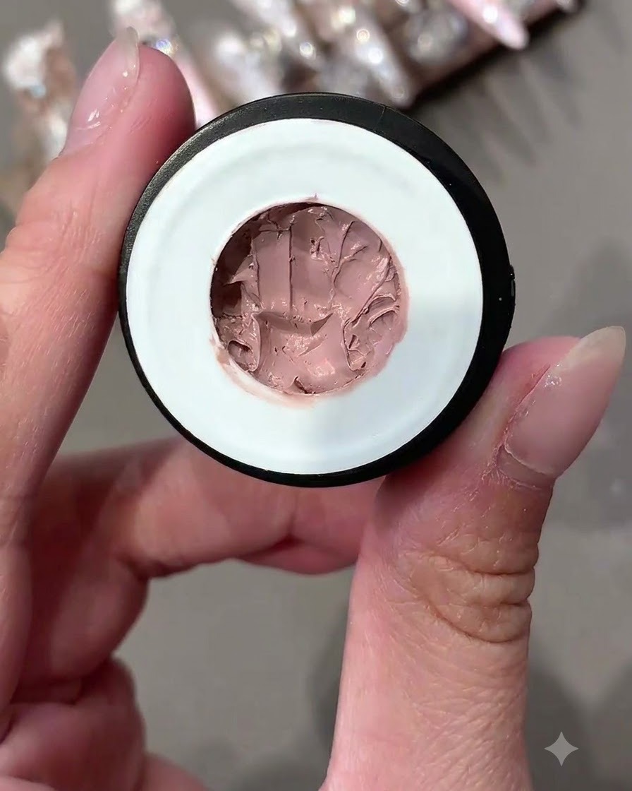 Un vasetto aperto di pudding gel solido dalle tonalità rosa mostrato in primo piano.