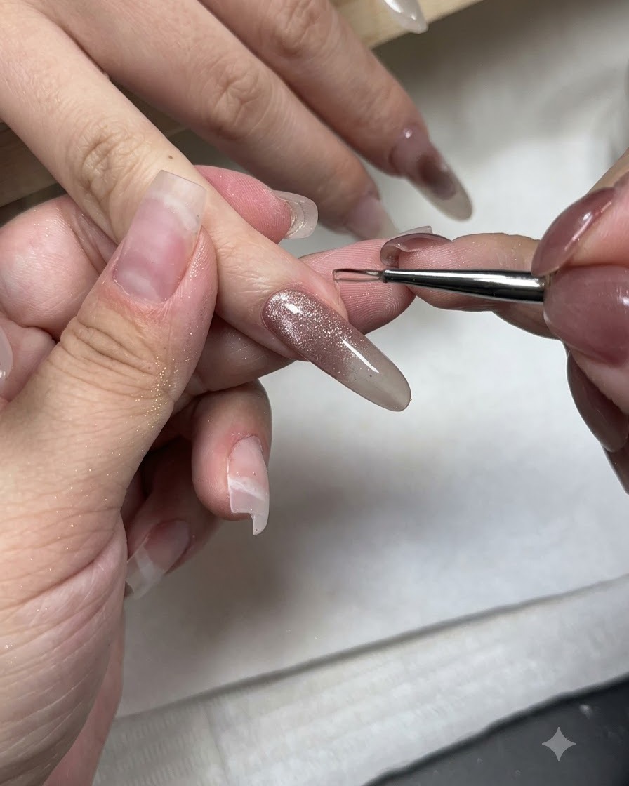 Un pennello fine per nail art applica gel styling no-wipe sulla punta di ununghia in gel cat-eye.