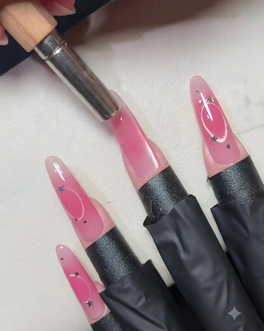Un magnete cilindrico tenuto verticalmente sopra il centro di ununghia in gel cat eye rosa.