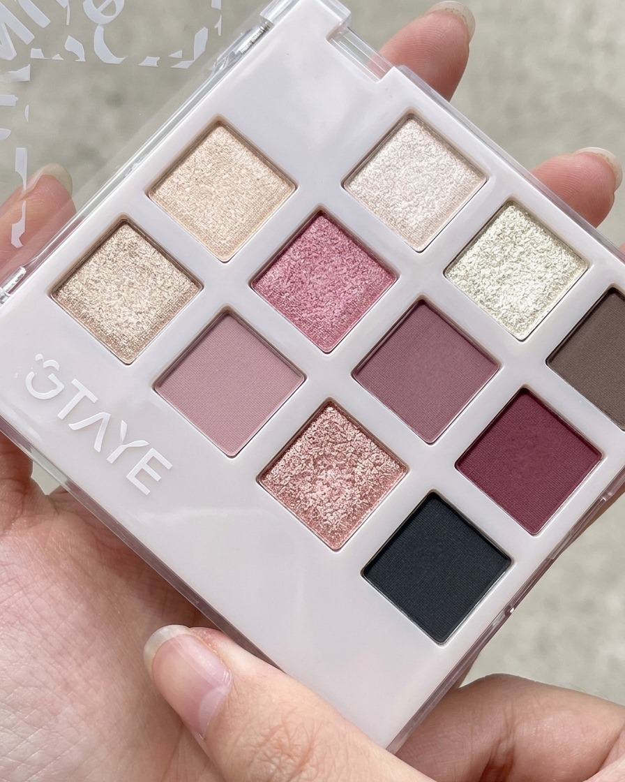 Uno strumento in silicone che preleva del gel rosa pesca da una palette per miscelazione.