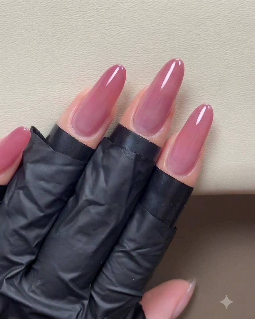 Unapplicazione completata di gel cat-eye rosa-oro che copre uniformemente la superficie delle unghie lunghe preparate.